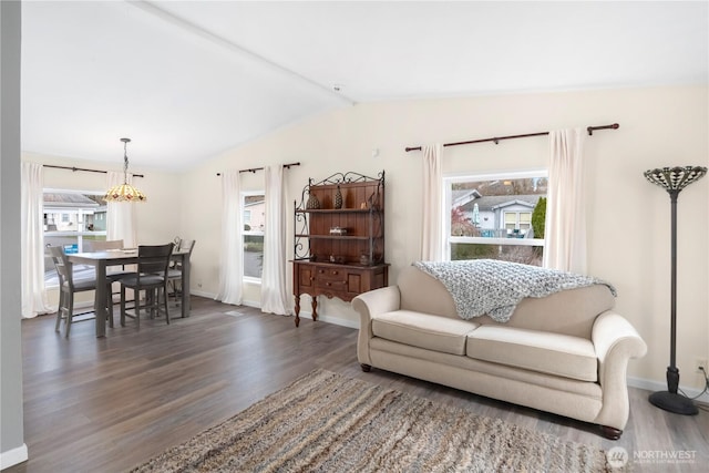 living area with baseboards, lofted ceiling, and wood finished floors