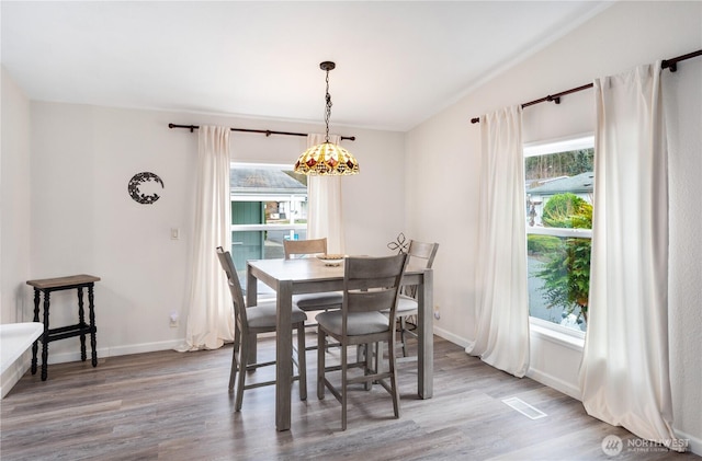 dining room with plenty of natural light, visible vents, and wood finished floors