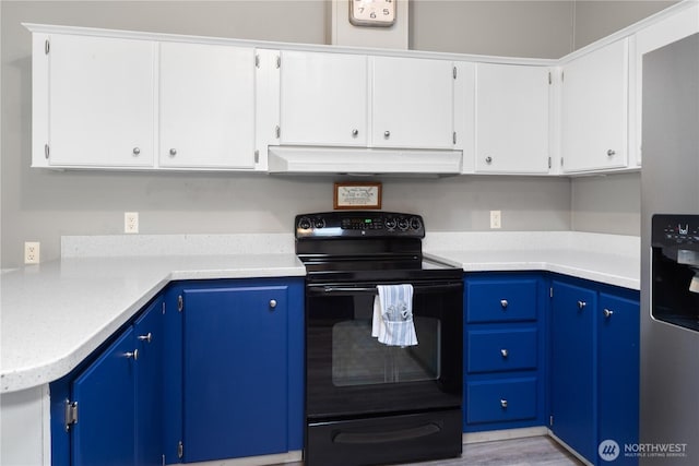 kitchen with under cabinet range hood, stainless steel fridge, light countertops, and black electric range