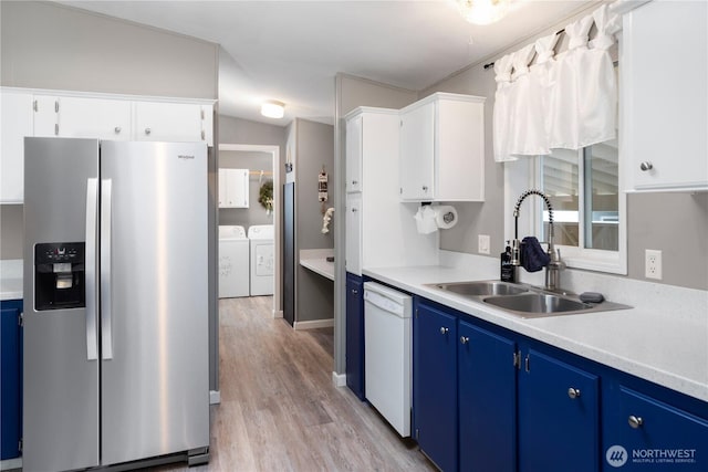 kitchen featuring a sink, blue cabinets, stainless steel fridge, and dishwasher