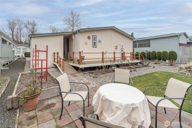 rear view of property with a yard, a vegetable garden, and a deck