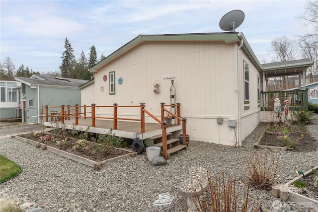 back of property featuring a deck and a garden