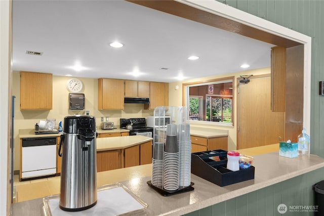 kitchen with white appliances, recessed lighting, light countertops, and under cabinet range hood