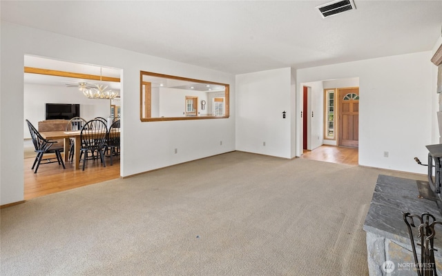 living room with an inviting chandelier, carpet, and visible vents