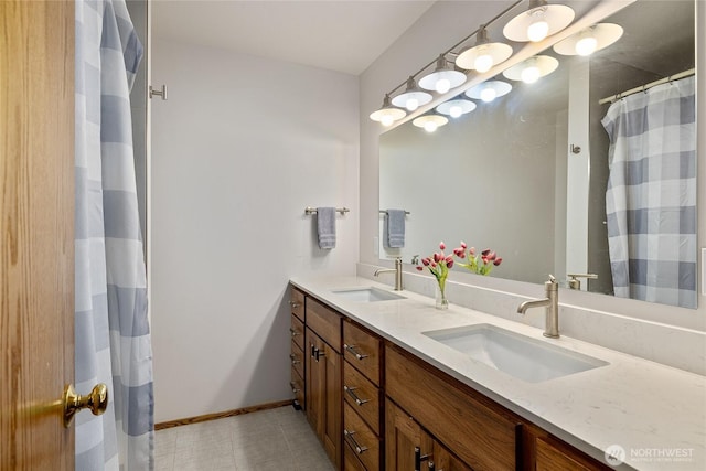 bathroom featuring double vanity, tile patterned floors, baseboards, and a sink