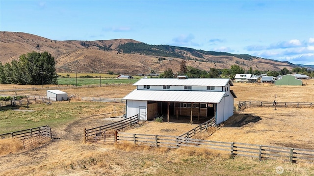 view of outbuilding featuring a rural view, an exterior structure, a mountain view, and an outdoor structure