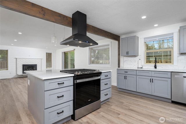 kitchen with ventilation hood, beamed ceiling, gray cabinets, and appliances with stainless steel finishes