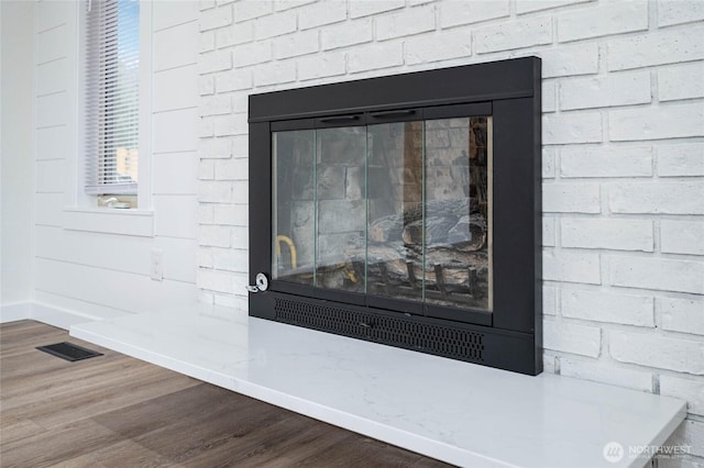 details featuring visible vents, baseboards, and wood finished floors