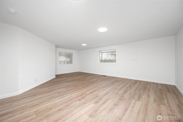 empty room featuring baseboards and light wood finished floors