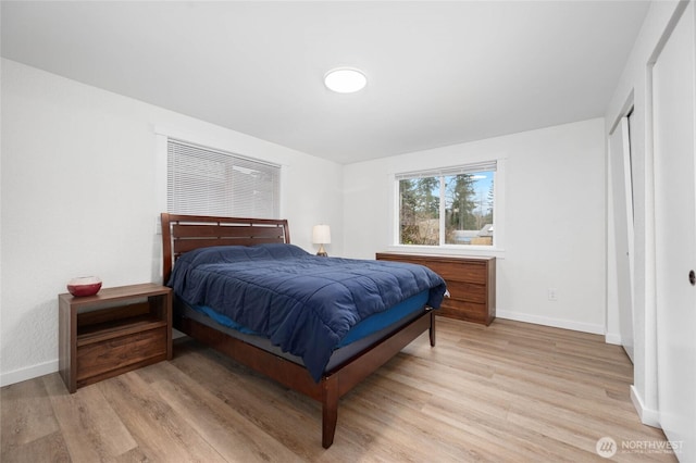 bedroom with light wood-type flooring and baseboards