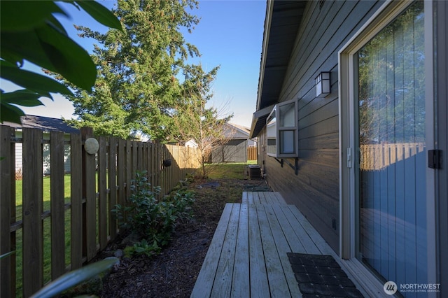 deck with cooling unit and a fenced backyard