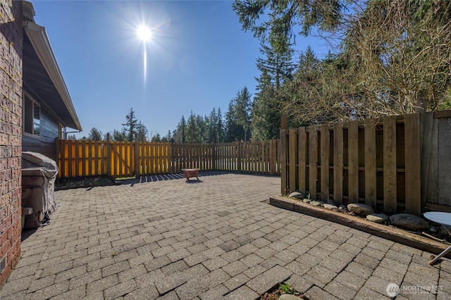 view of patio with area for grilling and a fenced backyard