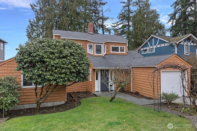 view of front facade with a front lawn, roof with shingles, and a chimney