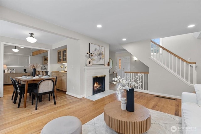 living area featuring stairway, light wood-style flooring, recessed lighting, and baseboards