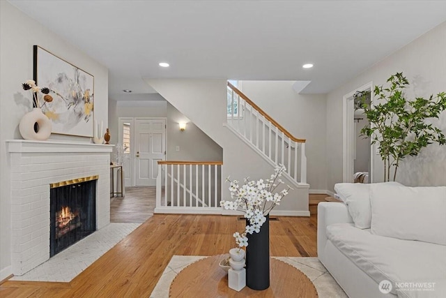 living room with a fireplace, recessed lighting, wood finished floors, and baseboards