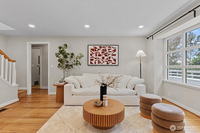 living area with recessed lighting, stairway, baseboards, and light wood-style floors