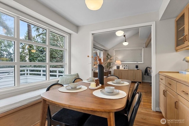 dining area featuring lofted ceiling and light wood-style flooring