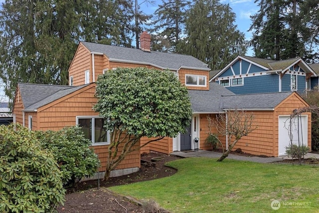 view of front of home with a chimney, a shingled roof, and a front yard