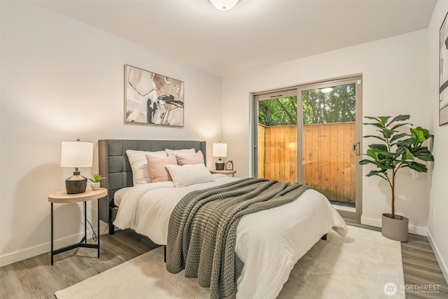 bedroom with access to exterior, wood finished floors, and baseboards