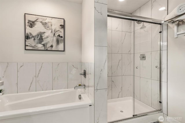 full bath featuring a shower stall and a garden tub