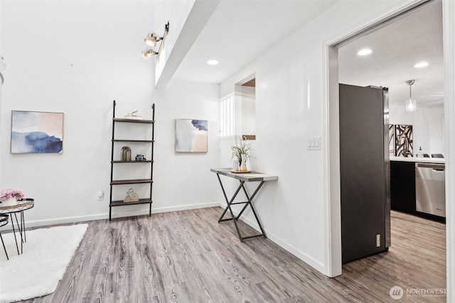 hallway featuring recessed lighting, baseboards, and wood finished floors