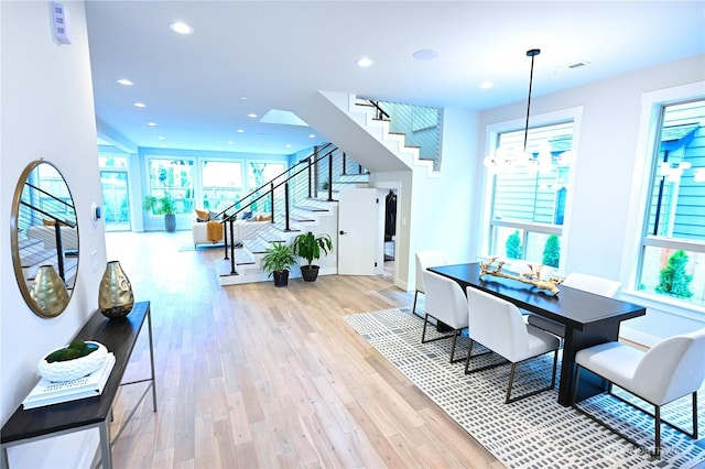 dining area featuring visible vents, a notable chandelier, light wood-style flooring, recessed lighting, and stairway