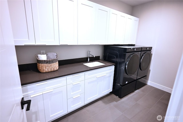 clothes washing area featuring tile patterned floors, independent washer and dryer, a sink, cabinet space, and baseboards