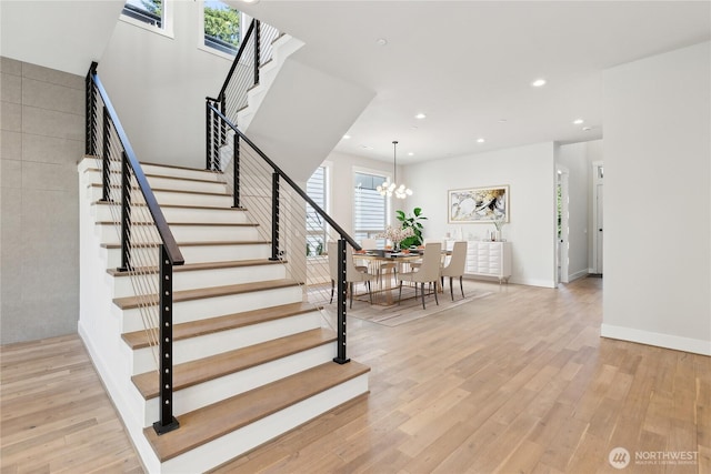 staircase featuring recessed lighting, baseboards, an inviting chandelier, and wood finished floors