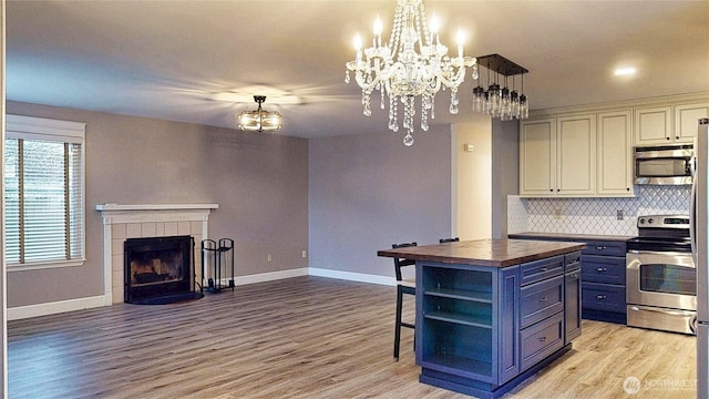 kitchen with wooden counters, open floor plan, stainless steel appliances, blue cabinets, and open shelves