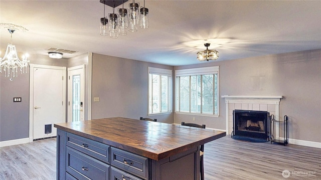 kitchen featuring visible vents, light wood-style floors, an inviting chandelier, and butcher block counters