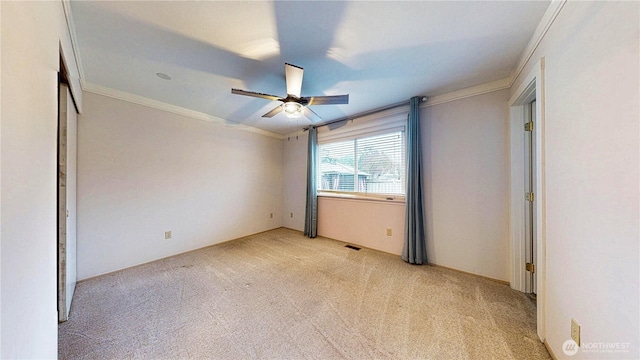 unfurnished bedroom with light carpet, ceiling fan, and ornamental molding