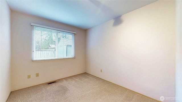 empty room with light colored carpet and visible vents