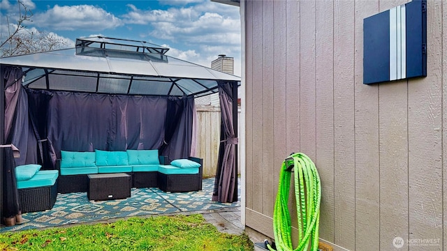 view of patio with a gazebo, an outdoor hangout area, and fence