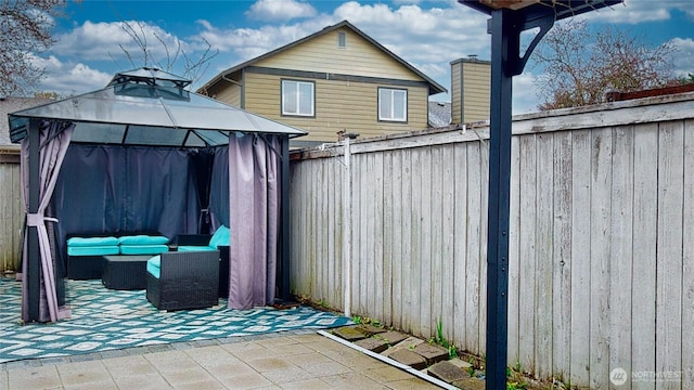 view of patio with a gazebo, a fenced backyard, and an outdoor hangout area