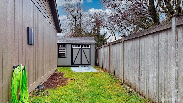 view of yard with an outbuilding, a storage unit, and a fenced backyard