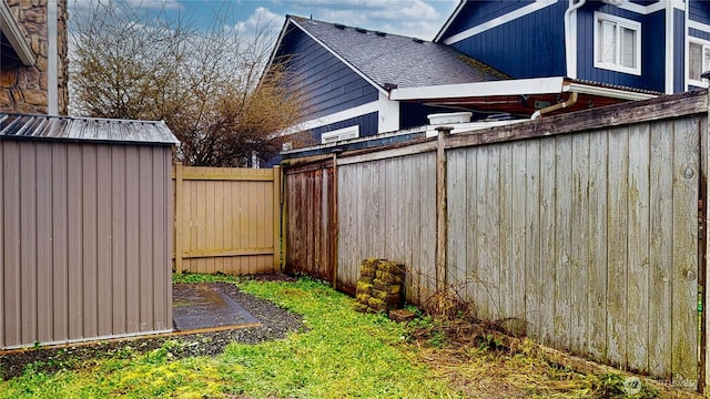 view of yard featuring a shed, an outdoor structure, and a fenced backyard