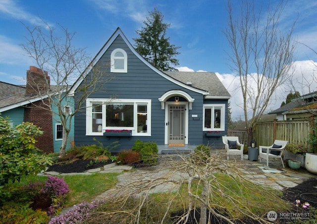 bungalow-style home with a patio area, roof with shingles, and fence