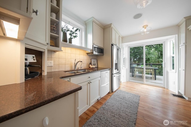 kitchen with a sink, stainless steel appliances, plenty of natural light, and visible vents