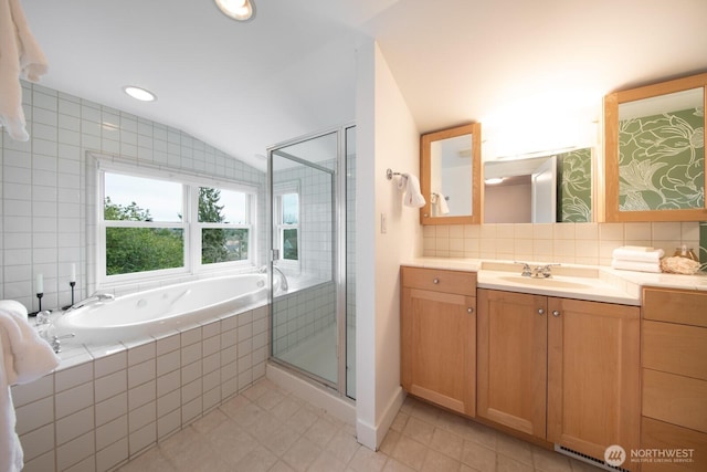 bathroom featuring vaulted ceiling, a bath, a stall shower, and backsplash