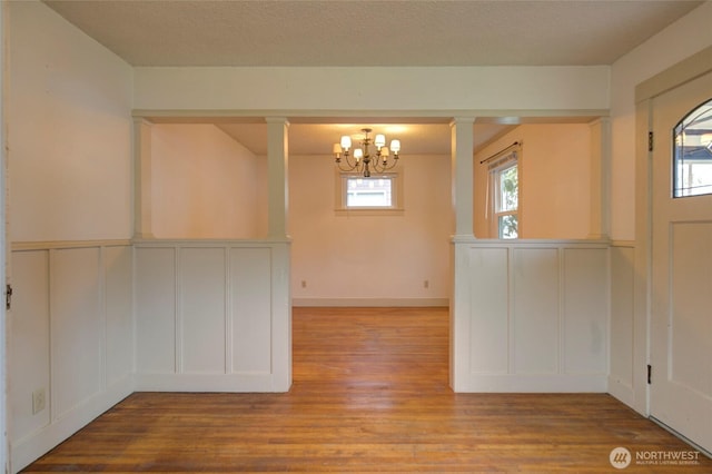 446 Eklund Ave, Hoquiam, WA 98550 - foyer featuring a textured ceiling, wood finished floors, a decorative wall, and an inviting chandelier