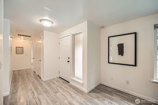 entrance foyer with light wood-style floors, visible vents, and baseboards