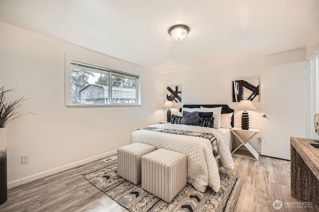 bedroom with baseboards and light wood finished floors