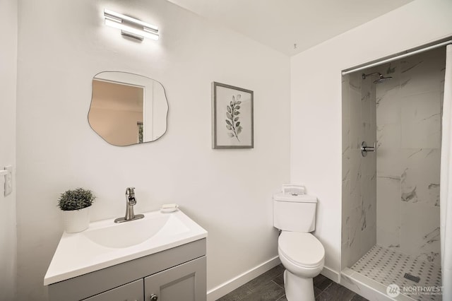 full bath featuring vanity, wood finished floors, baseboards, a stall shower, and toilet