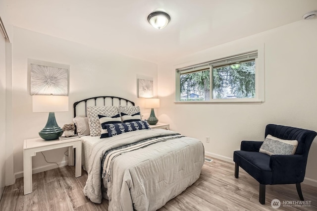 bedroom with baseboards and light wood-type flooring