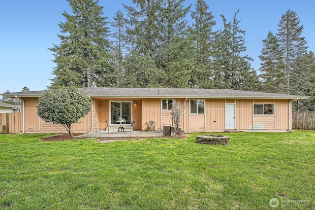 rear view of property featuring a patio area, a lawn, and fence