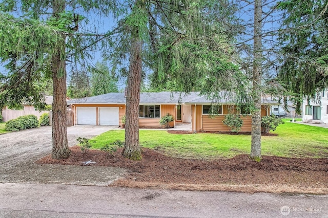 ranch-style home featuring an attached garage, concrete driveway, and a front lawn