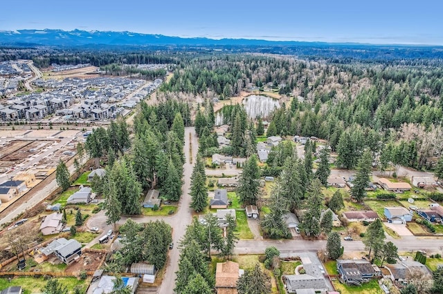 aerial view featuring a mountain view, a view of trees, and a residential view