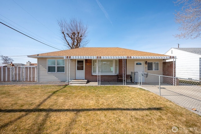 view of front of house featuring a front lawn, entry steps, fence, roof with shingles, and brick siding