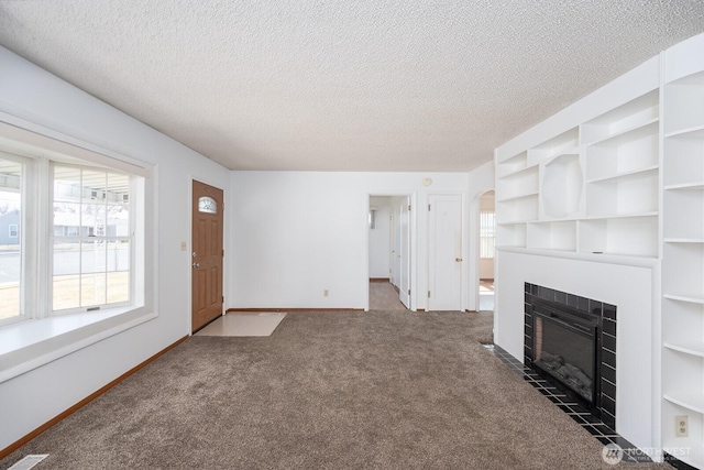 unfurnished living room with a fireplace, baseboards, carpet floors, and a textured ceiling