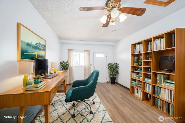 home office with a textured ceiling, wood finished floors, and ceiling fan